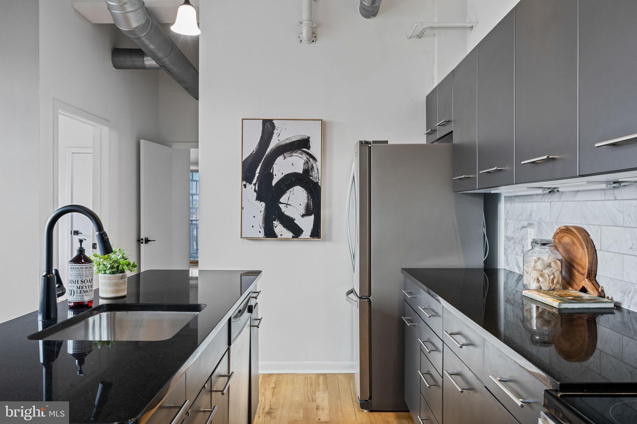 2200-28 Arch Street, Unit 612 Philadelphia, PA 19103 - Photo 9 of 43 a kitchen with a stove and a sink with wooden cabinets