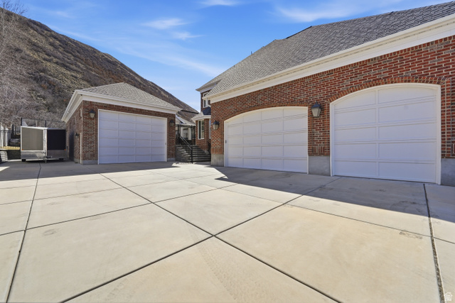 714 Draper Heights Way Draper, UT 84020 - Photo 80 of 88 View of side of property featuring a shingled roof, driveway, brick siding, and an outbuilding