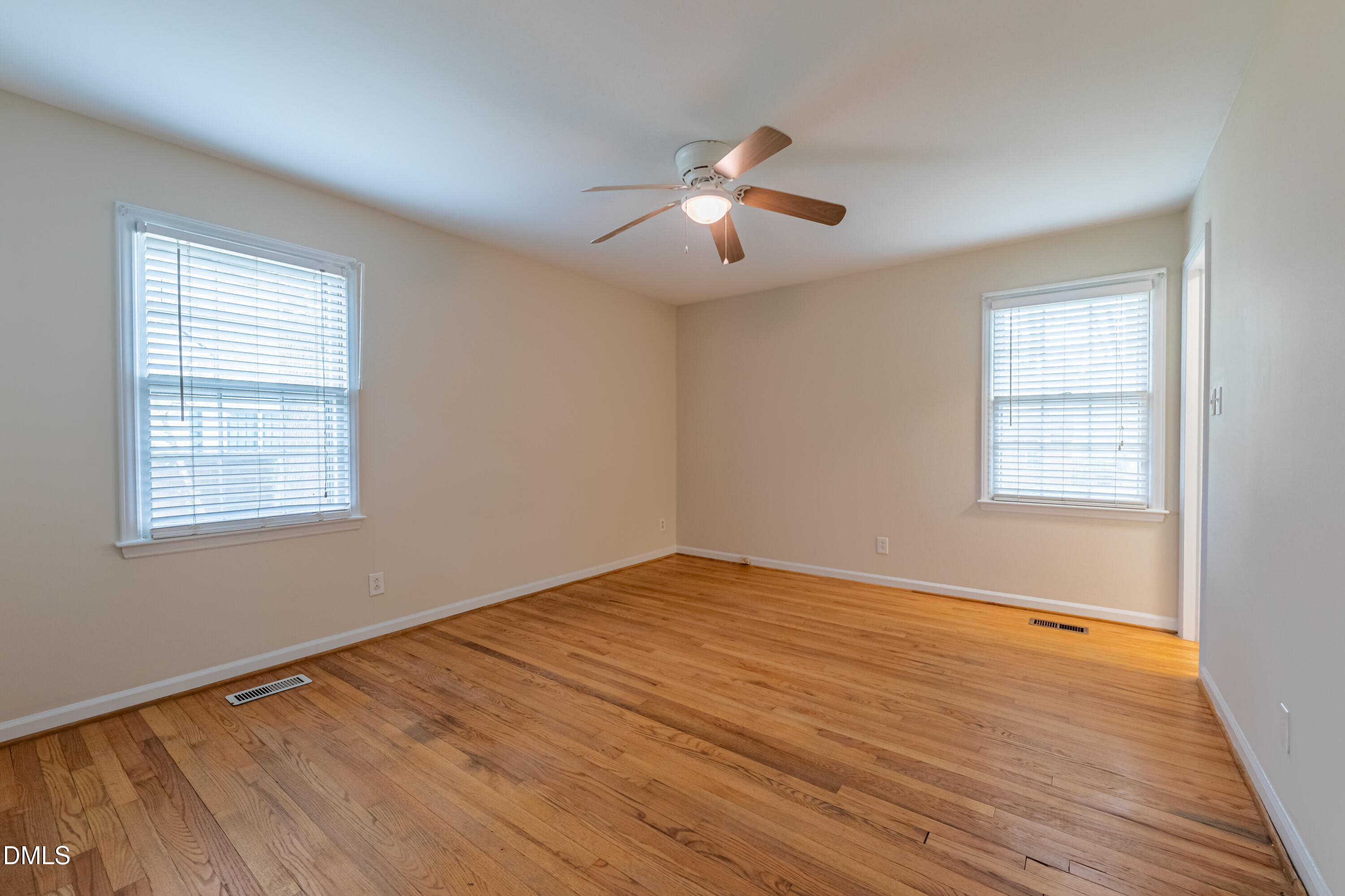 408 Ortega Road Raleigh, NC 27609 - Photo 13 of 25 a view of an empty room with wooden floor and a window