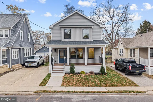 a view of a white house with large windows next to a road