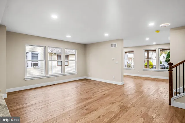 a kitchen with wooden floors and white cabinets