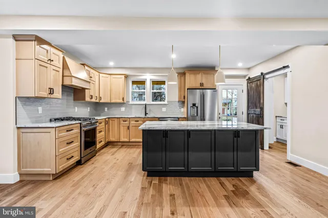a kitchen with granite countertop a refrigerator stove top oven and sink