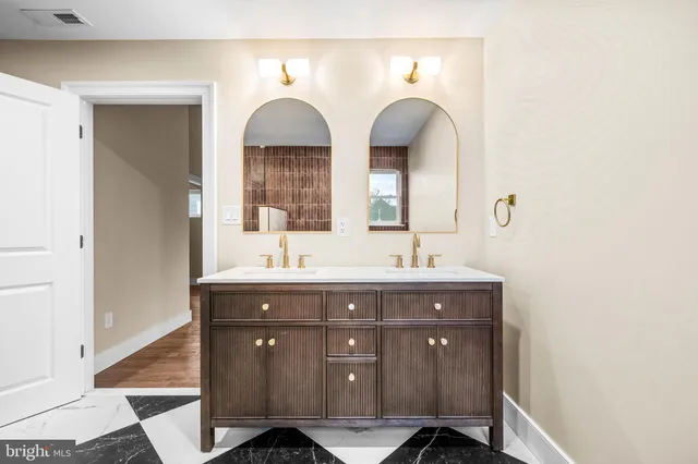 a bathroom with a granite countertop sink a toilet a mirror a bathtub and shower