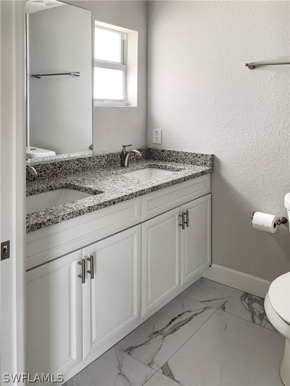 7418 Albany Road, Unit 7418 Fort Myers, FL 33967 - Photo 10 of 11 a bathroom with a granite countertop sink and a toilet