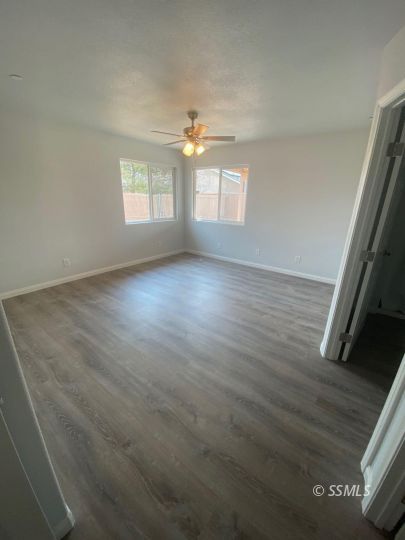 1009 West Boston Avenue Ridgecrest, CA 93555 - Photo 7 of 9 an empty room with wooden floor cabinet and windows