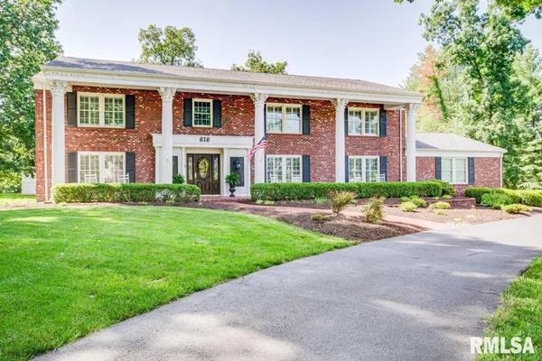 a front view of a house with yard and green space