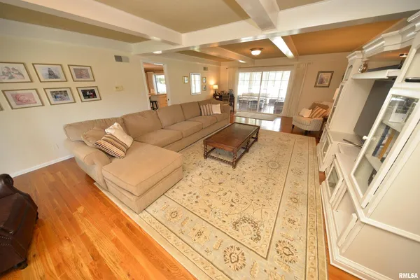 a living room with furniture pool table chairs and a flat screen tv