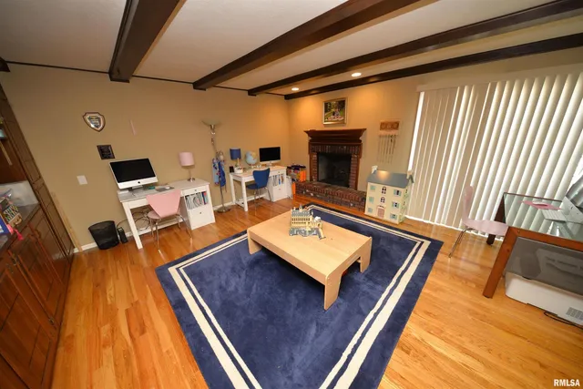 a living room with furniture a fireplace and a large window