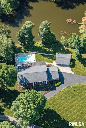 an aerial view of a house having swimming pool and a yard
