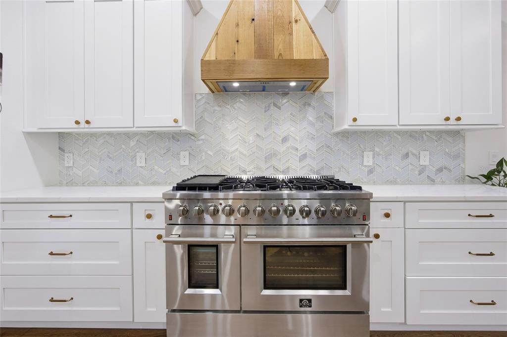 12052 Southeast 101st Court Road Belleview, FL 34420 - Photo 17 of 74 a stove top oven sitting inside of a kitchen and white cabinets