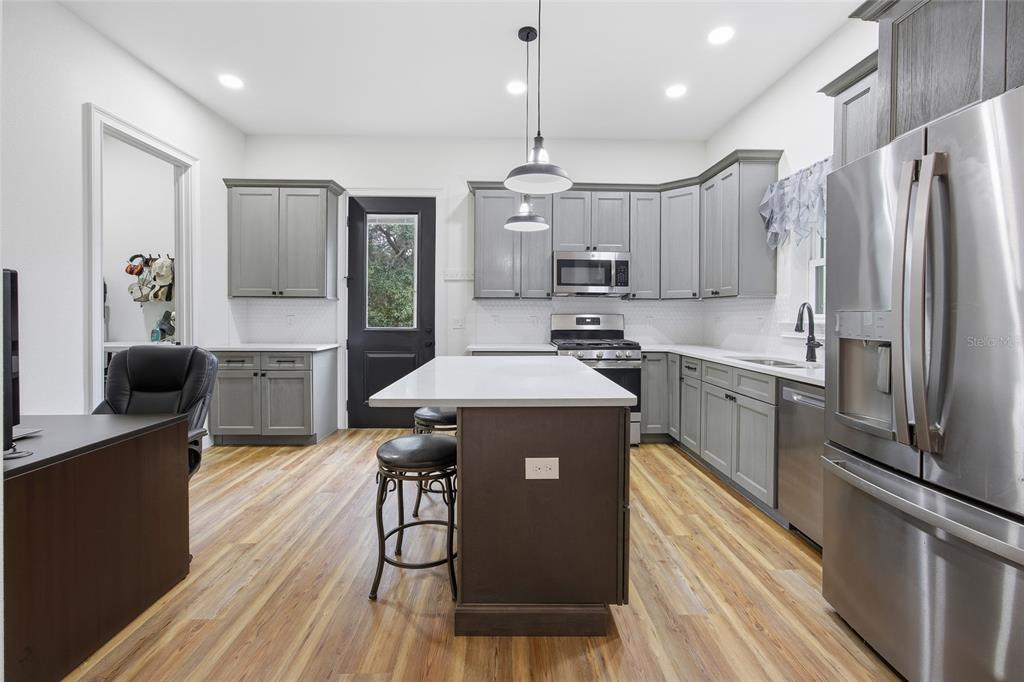 12052 Southeast 101st Court Road Belleview, FL 34420 - Photo 46 of 74 a kitchen with kitchen island a counter top space a sink stainless steel appliances and cabinets