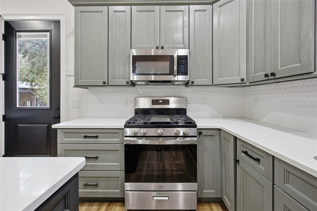 12052 Southeast 101st Court Road Belleview, FL 34420 - Photo 49 of 74 a kitchen with granite countertop white cabinets and stainless steel appliances