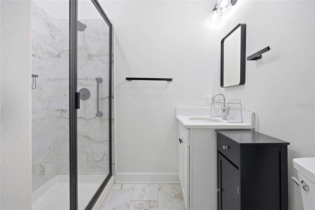 12052 Southeast 101st Court Road Belleview, FL 34420 - Photo 53 of 74 a bathroom with a sink mirror and shower