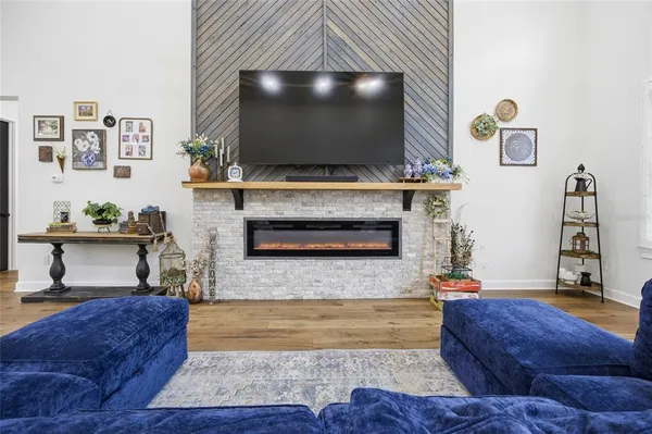a living room with furniture a flat screen tv and kitchen view