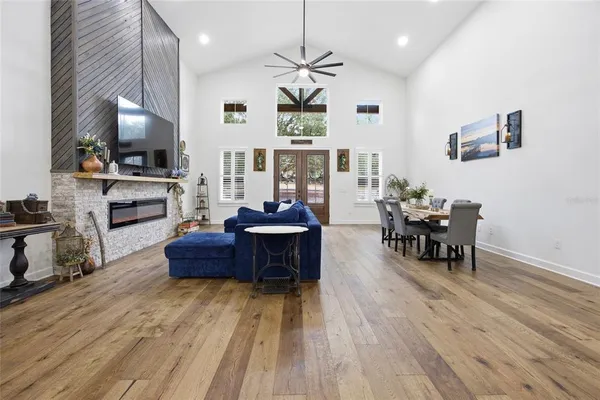 a large kitchen with stainless steel appliances granite countertop a stove a sink dishwasher and a dining table with wooden floor