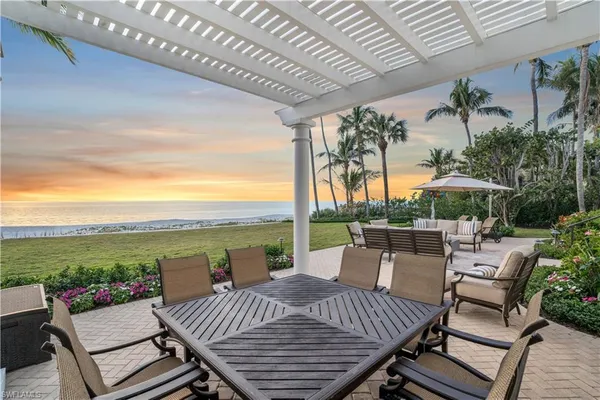 a view of a patio with lawn chairs next to a yard
