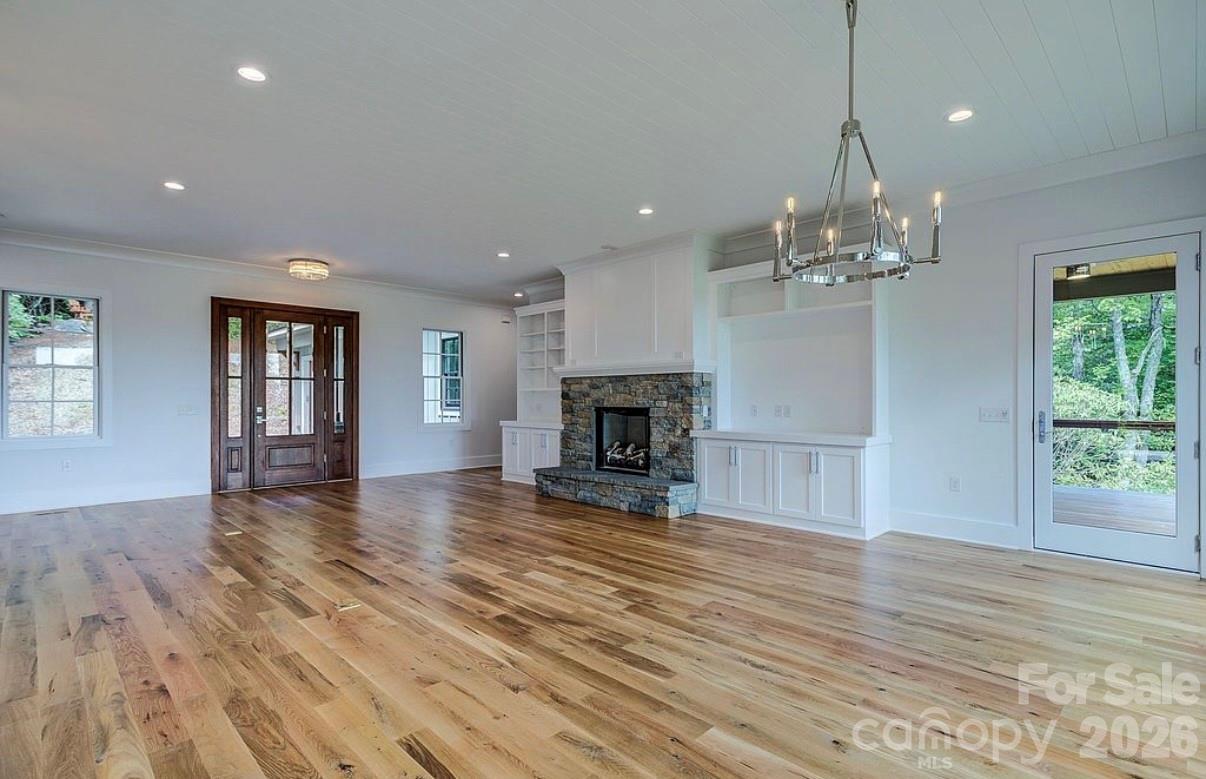3434 Old Jonas Ridge Road Newland, NC 28657 - Photo 21 of 46 an empty room with wooden floor and fireplace