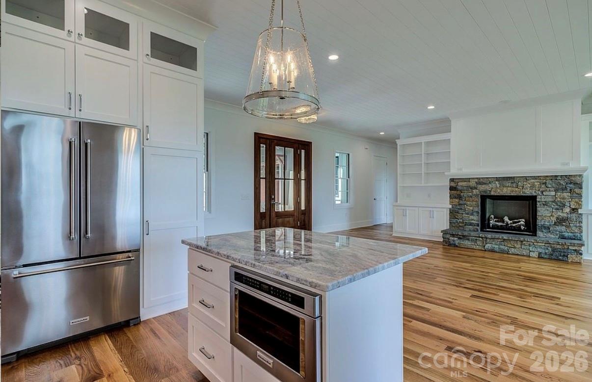 3434 Old Jonas Ridge Road Newland, NC 28657 - Photo 23 of 46 a kitchen with stainless steel appliances granite countertop a refrigerator a stove and a wooden floors