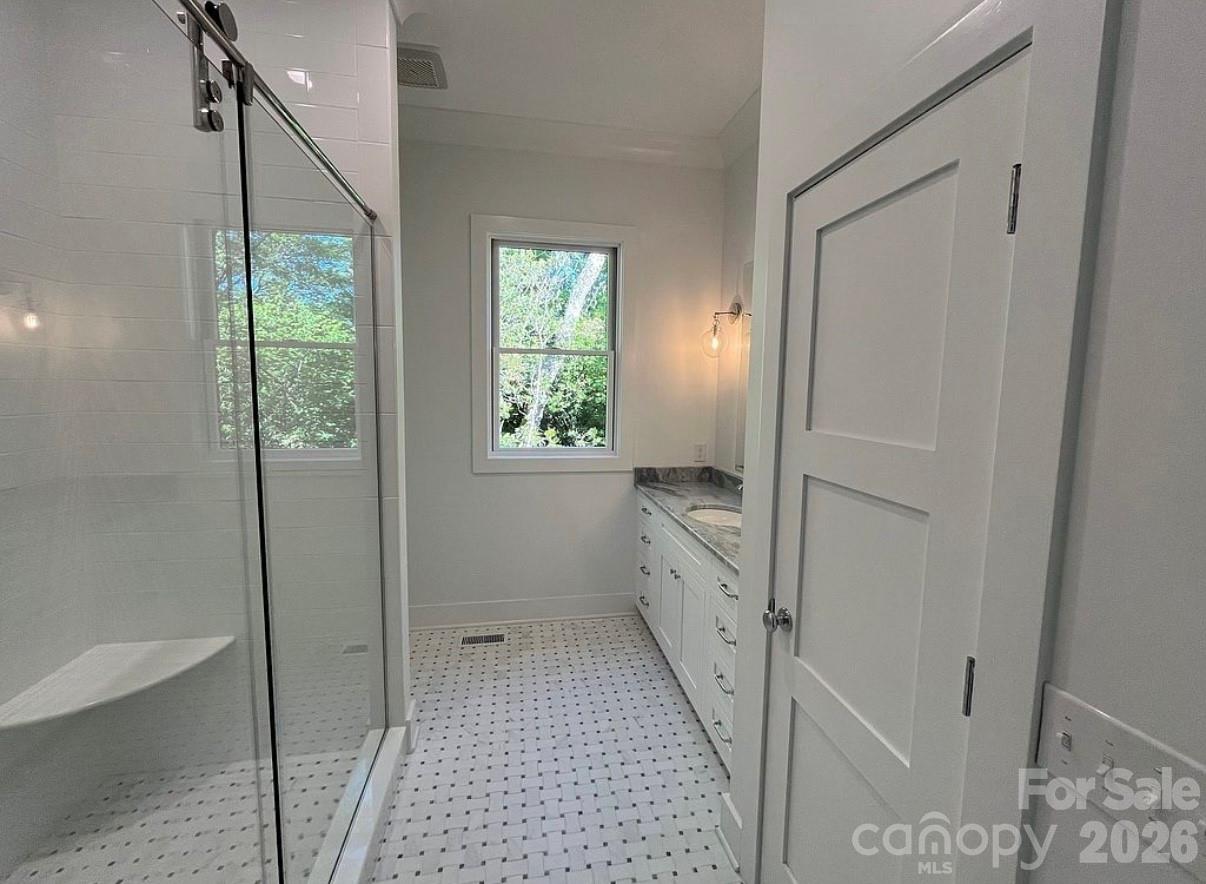 3434 Old Jonas Ridge Road Newland, NC 28657 - Photo 31 of 46 a bathroom with a granite countertop sink a mirror and a shower