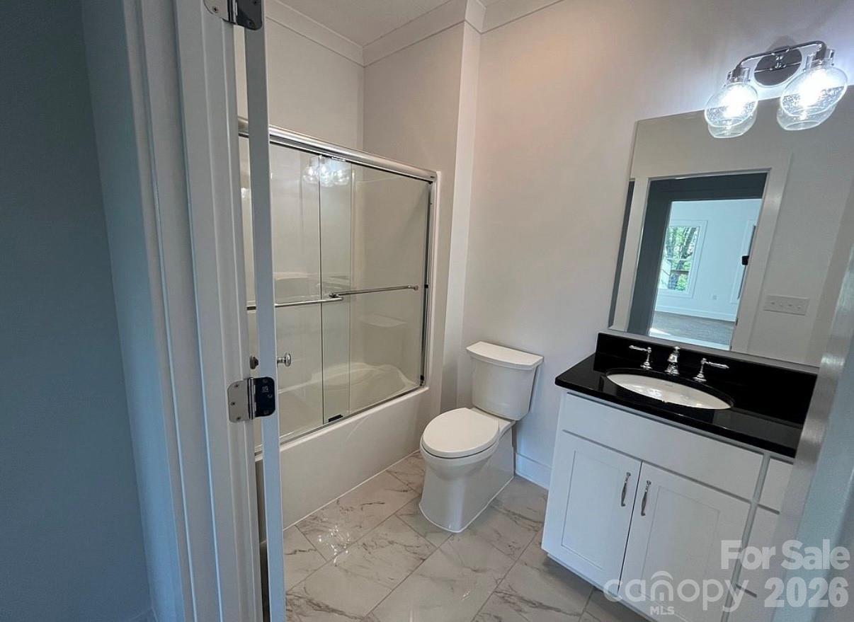 3434 Old Jonas Ridge Road Newland, NC 28657 - Photo 39 of 46 a bathroom with a granite countertop sink a toilet a mirror and shower