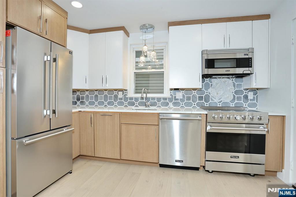 a kitchen with granite countertop white cabinets and stainless steel appliances