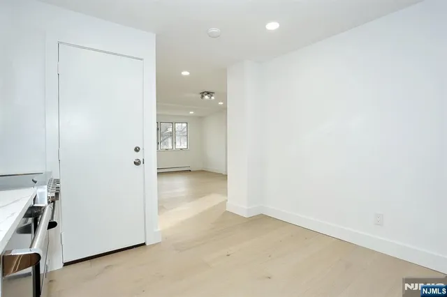 an empty room with a cabinet and mirrors