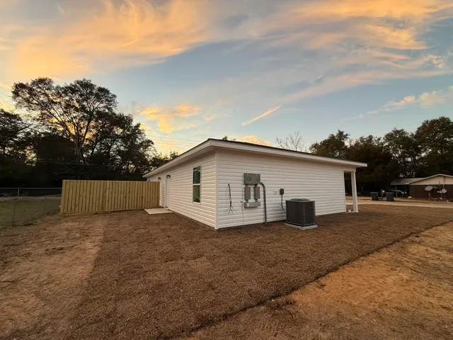 a view of a house with a yard and large tree