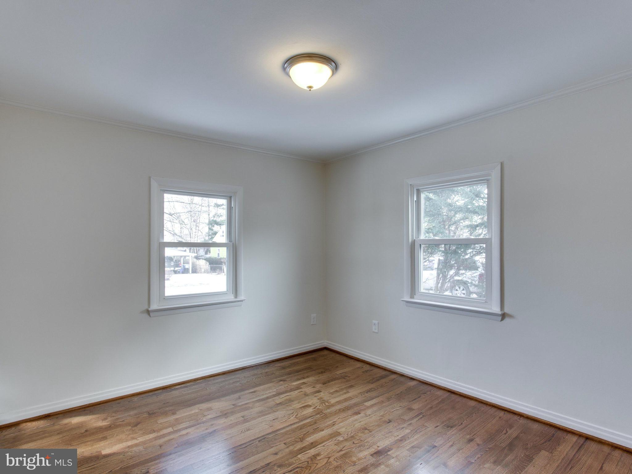 11606 Joseph Mill Road Silver Spring, MD 20906 - Photo 14 of 30 a view of an empty room with wooden floor and a window