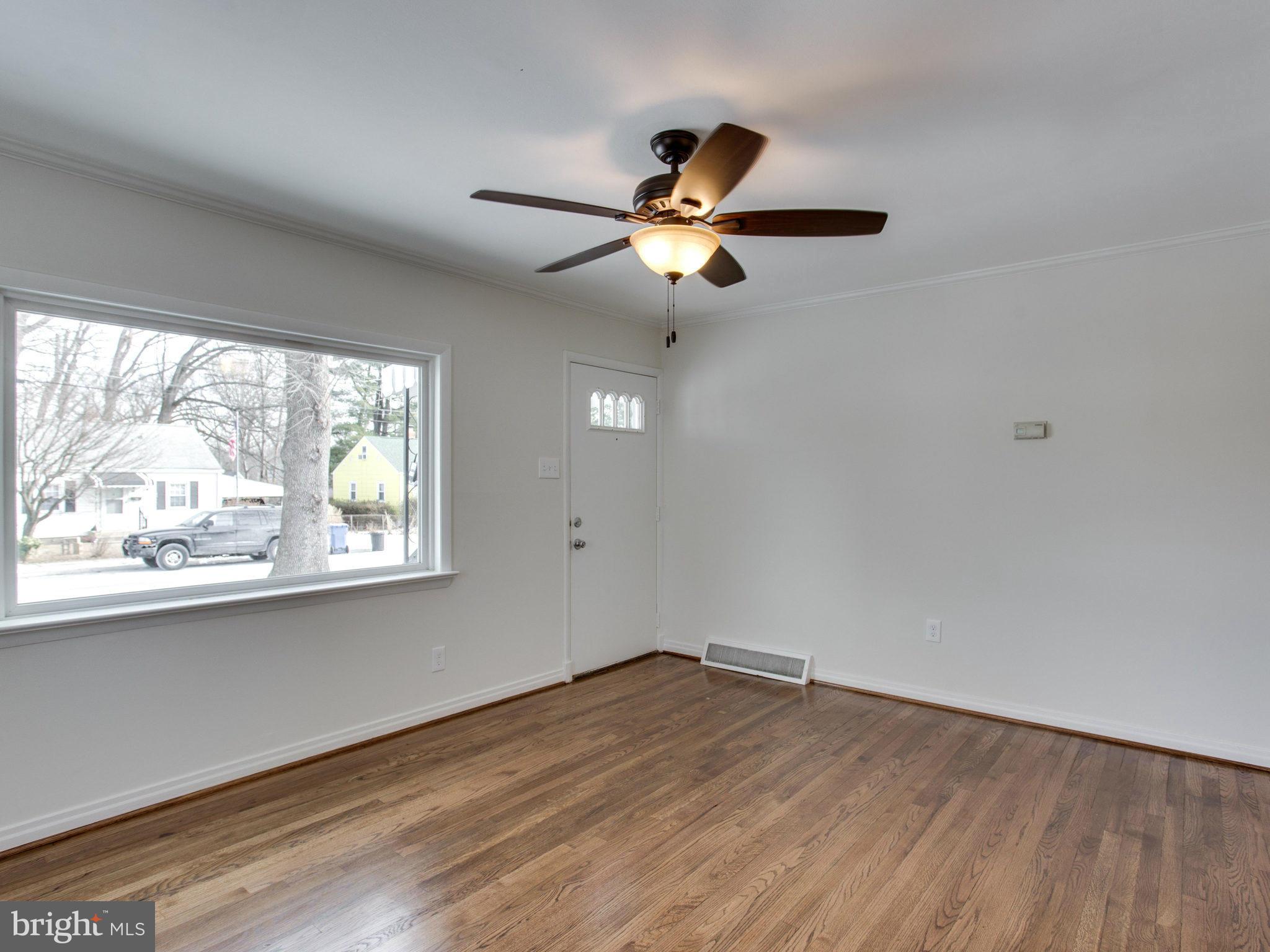11606 Joseph Mill Road Silver Spring, MD 20906 - Photo 4 of 30 an empty room with wooden floor fan and windows