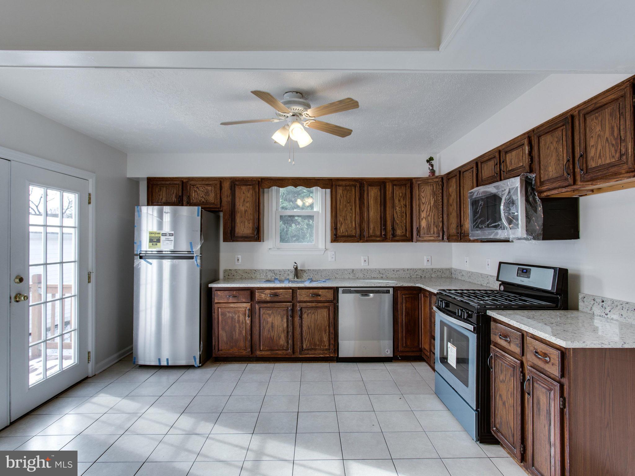 11606 Joseph Mill Road Silver Spring, MD 20906 - Photo 7 of 30 a kitchen with stainless steel appliances granite countertop a stove top oven a sink dishwasher and a refrigerator