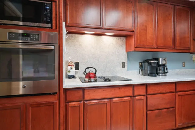 a kitchen with stainless steel appliances granite countertop wooden cabinets and a stove