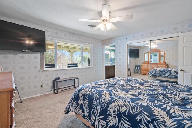 a bedroom with a large bed and a flat screen tv