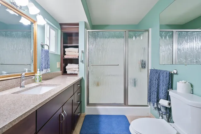 a bathroom with a granite countertop sink toilet and shower