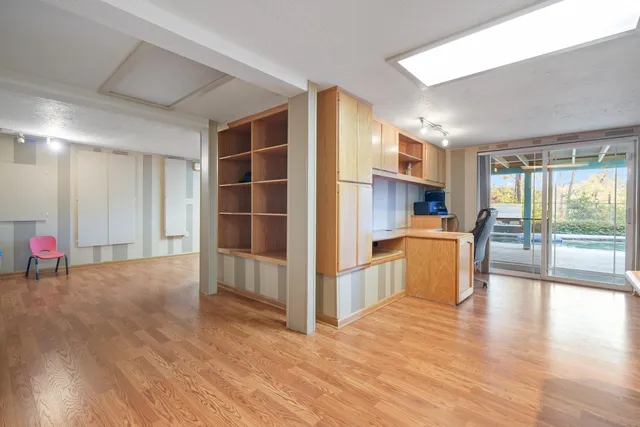 a view of a kitchen with furniture and wooden floor