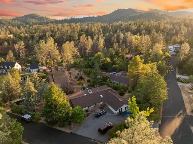 an aerial view of house with yard and mountain view in back