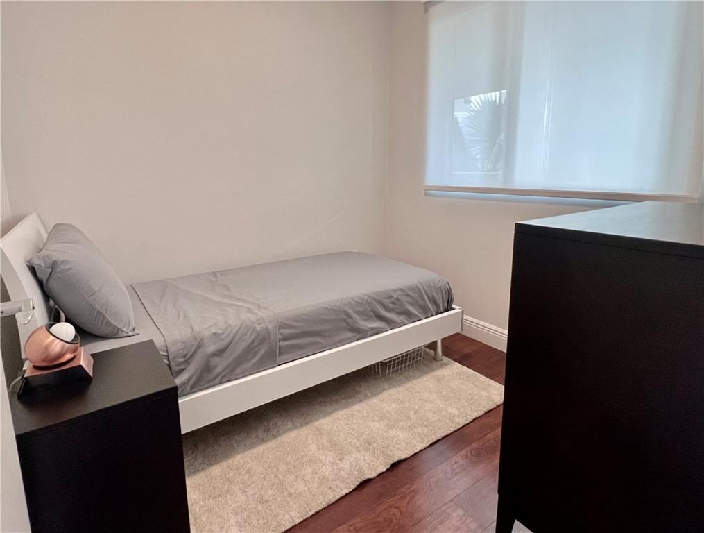 7275 Southwest 90th Way, Unit 504 Miami, FL 33156 - Photo 11 of 24 a bed sitting in a bedroom next to a window with wooden floor