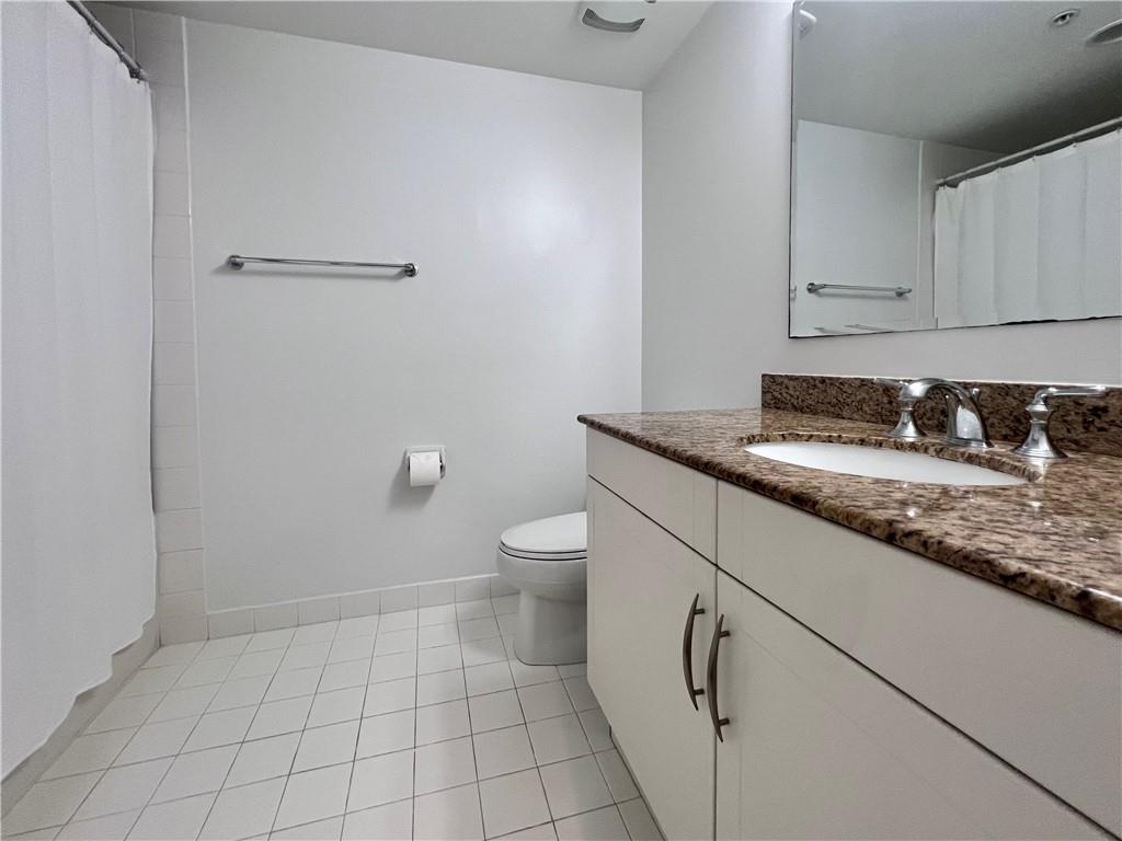 7275 Southwest 90th Way, Unit 504 Miami, FL 33156 - Photo 13 of 24 a bathroom with a granite countertop toilet and sink