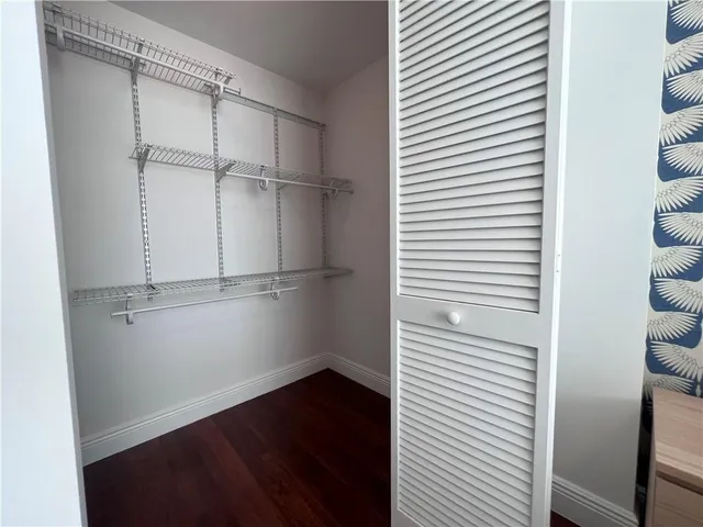 a bedroom with a bed and a lamp with wooden floor