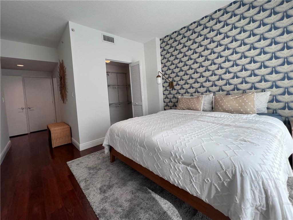 7275 Southwest 90th Way, Unit 504 Miami, FL 33156 - Photo 17 of 24 a bedroom with a bed and a lamp with wooden floor