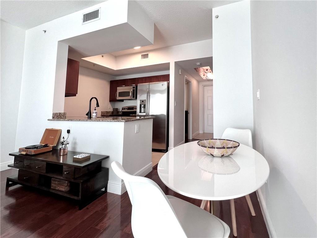 7275 Southwest 90th Way, Unit 504 Miami, FL 33156 - Photo 18 of 24 a living room with stainless steel appliances kitchen island granite countertop furniture and wooden floor