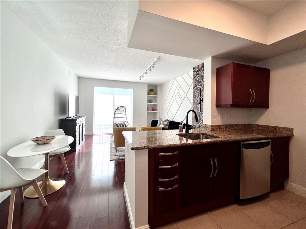7275 Southwest 90th Way, Unit 504 Miami, FL 33156 - Photo 5 of 24 a kitchen with a sink cabinets and wooden floor