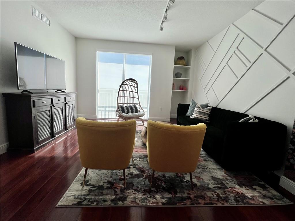 7275 Southwest 90th Way, Unit 504 Miami, FL 33156 - Photo 6 of 24 a living room with furniture a flat screen tv and a wooden floor