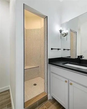 a bathroom with a granite countertop sink a mirror and a shower
