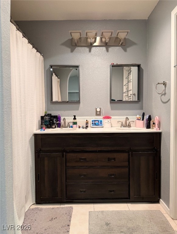 881 Brass Ring Road Las Vegas, NV 89123 - Photo 6 of 13 Full bath featuring a textured wall, double vanity, light tile patterned floors, and curtained shower