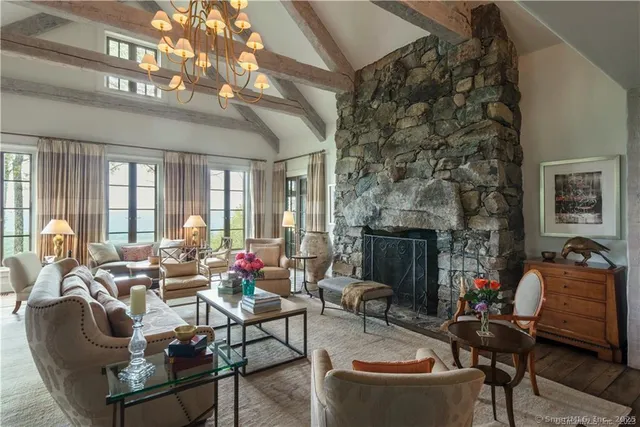 a living room with furniture a fireplace and a chandelier