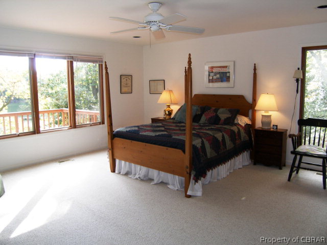 879 West Point Road Lancaster, VA 22503 - Photo 13 of 38 a spacious bedroom with a bed a table and chair