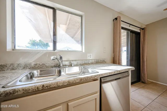a kitchen with granite countertop stainless steel appliances a sink and a window