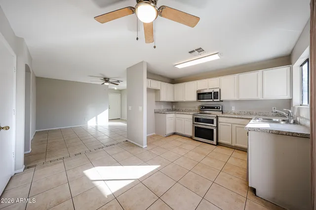 a kitchen with a stove a refrigerator and white cabinets
