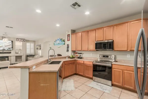 a kitchen with stainless steel appliances granite countertop a sink dishwasher stove and refrigerator