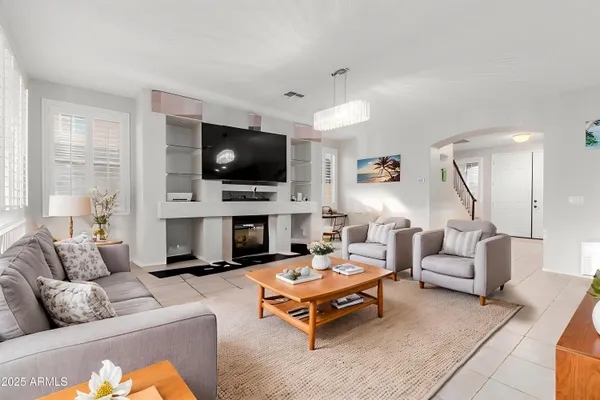 a living room with furniture a flat screen tv and a fireplace